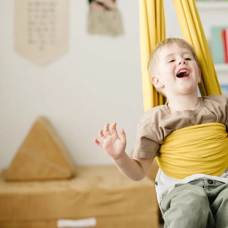 Criança brincando em balanço sensorial infantil dourado