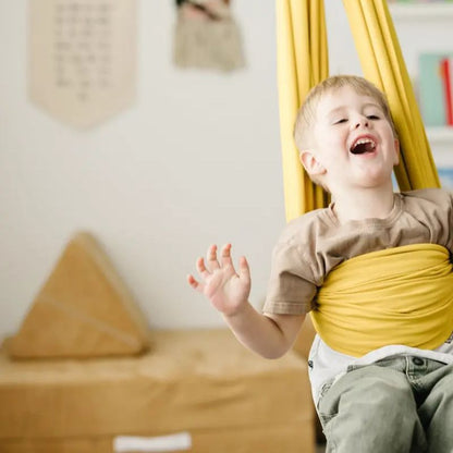 Criança brincando em balanço sensorial infantil dourado