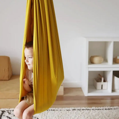 Balanço sensorial infantil dourado instalado dentro de casa